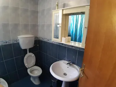 a bathroom with a toilet and a sink and a mirror at Vesna Apartments in Ulcinj