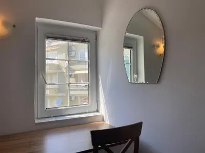 a mirror and a chair in a room with a window at Coastal Two Bedroom Comfort in Budva