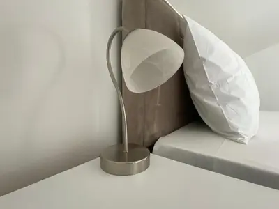 a metal lamp on a table next to a bed at Coastal Two Bedroom Comfort in Budva