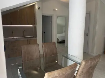 a kitchen with a glass table and two chairs at Coastal Two Bedroom Comfort in Budva