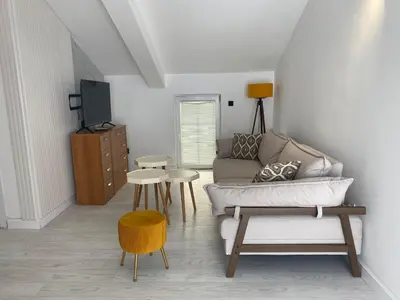 a living room with a couch and a tv at Coastal Two Bedroom Comfort in Budva