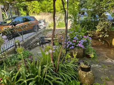 a garden with flowers and a bench and a car at Garden Apartments Budva in Boreti