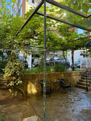 a patio with a table and chairs under a canopy at Garden Apartments Budva in Boreti