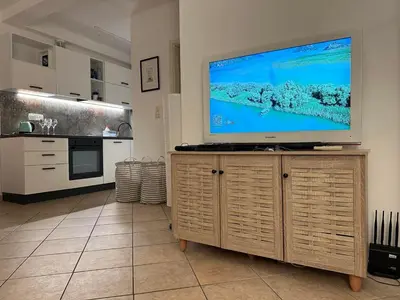 a living room with a large flat screen tv on a cabinet at Apartment Oliva, Rafailovici in Budva