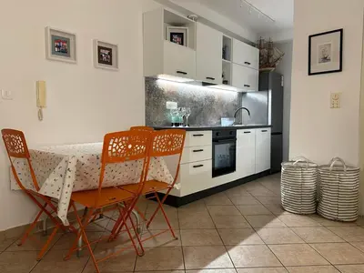 a kitchen with a table and chairs in a kitchen at Apartment Oliva, Rafailovici in Budva