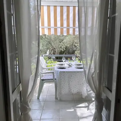 a white table and chair on a porch with a window at Apartment Oliva, Rafailovici in Budva