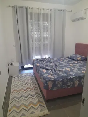 a bedroom with a bed and a window with curtains at Tina city apartment in Ulcinj