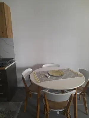 a table and chairs in a kitchen with a table at Tina city apartment in Ulcinj