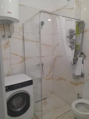 a bathroom with a washing machine and a toilet at Tina city apartment in Ulcinj
