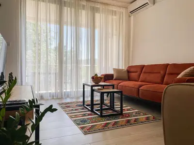 a living room with a red couch and a table at Cozy Karuč Home in Cetinje