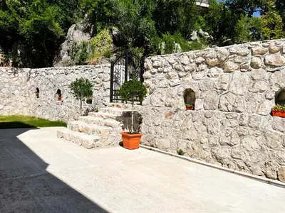 a stone wall with a potted plant in front of it at Cozy Karuč Home in Cetinje