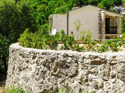 a stone wall in front of a house at Cozy Karuč Home in Cetinje