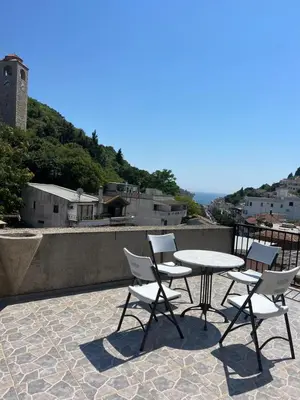 a patio with a table and chairs on a roof at Centrum Apartman & Rooms in Ulcinj