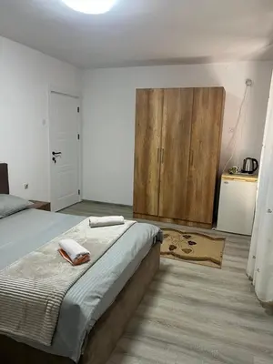 a bedroom with a bed and a wooden cabinet at Centrum Apartman & Rooms in Ulcinj