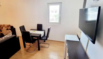 a living room with a table and chairs and a television at Studio Apartment Iva in Budva