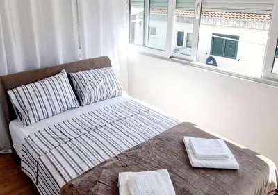 a bed with two towels on top of it in a bedroom at Studio Apartment Iva in Budva