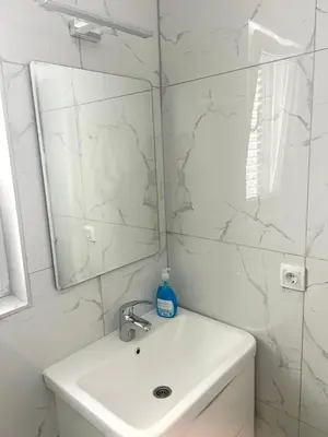 a white bathroom with a sink and a mirror at Studio Apartment Iva in Budva