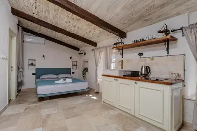 a bedroom with a bed and a kitchen at Casa Di Mino Old Town in Budva