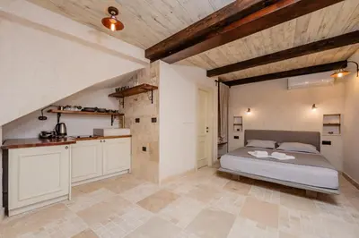 a large bedroom with a bed and a kitchen at Casa Di Mino Old Town in Budva