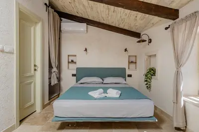 a bedroom with a bed with two towels on it at Casa Di Mino Old Town in Budva
