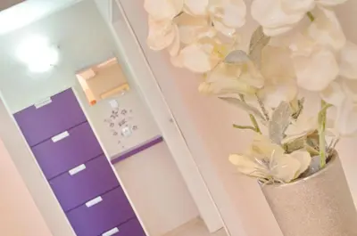 a vase with white flowers in front of a mirror at Apartments Dada in Kotor