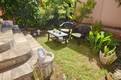a patio with a table and chairs in a yard at Apartments Dada in Kotor