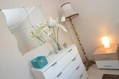 a dresser with a lamp and a vase of flowers on it at Apartments Dada in Kotor