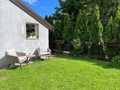 a yard with two chairs and a table in the grass at Guest house TAK in Cetinje