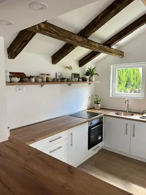 a kitchen with white cabinets and a window at Guest house TAK in Cetinje