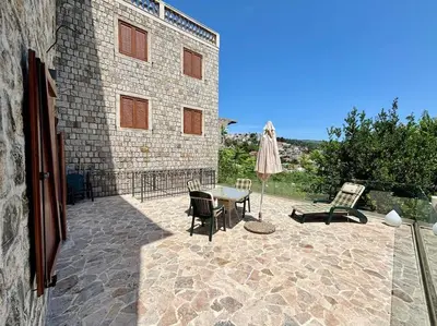 a patio with a table and chairs and an umbrella at Ulcinj - Stonehouse in Oldtown with sea view in Ulcinj