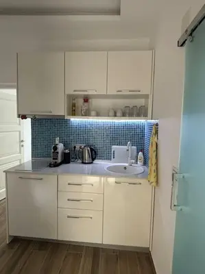 a kitchen with white cabinets and a sink at Ulcinj - Stonehouse in Oldtown with sea view in Ulcinj