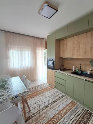 a kitchen with a table and chairs in a room at HOME POINT Apartment in Podgorica