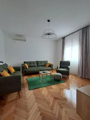 a living room with a green couch and a table at HOME POINT Apartment in Podgorica