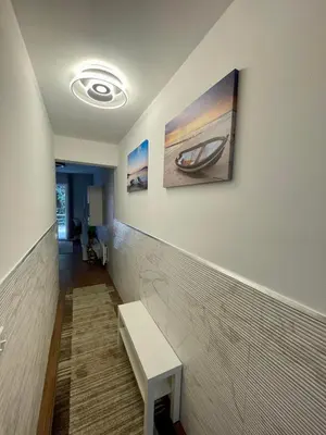a waiting room with a bench and paintings on the wall at Apartment Rafailovici in Rafailovici
