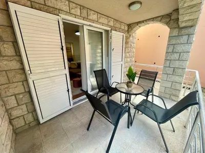 a patio with a table and chairs on a balcony at Apartment Rafailovici in Rafailovici