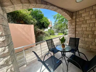 a patio with a table and chairs on a balcony at Apartment Rafailovici in Rafailovici