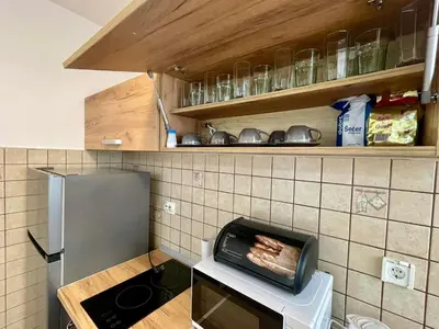 a kitchen with a grill with bacon on a toaster at Apartment Rafailovici in Rafailovici