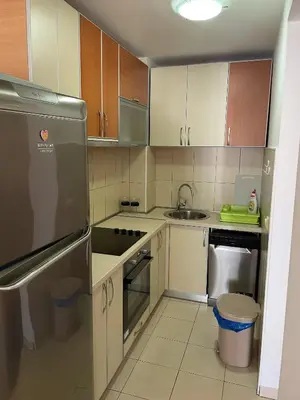 a kitchen with white cabinets and a stainless steel refrigerator at Bela Vista in Budva