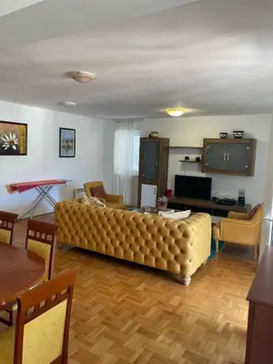 a living room with a large couch and a television at Bela Vista in Budva