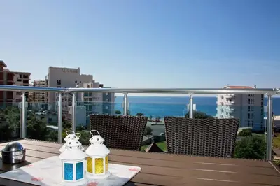 a table on a balcony with a view of the ocean at Sea view dobra voda in Dobra Voda