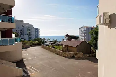 an empty parking lot with a building and the ocean at Sea view dobra voda in Dobra Voda