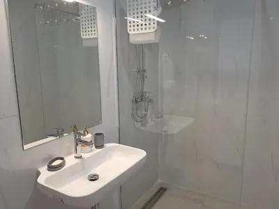 a white bathroom with a sink and a shower at VLSB Bečići in Becici