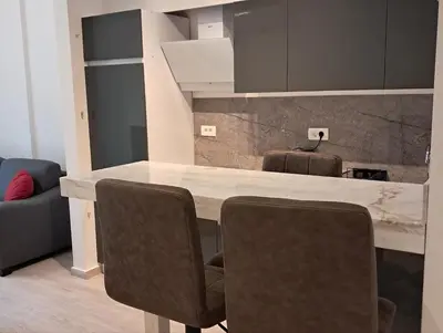 a kitchen with a table and some chairs at VLSB Bečići in Becici