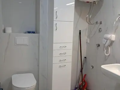 a white bathroom with a toilet and a sink at VLSB Bečići in Becici