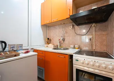 a kitchen with orange cabinets and a white stove top oven at Podgorica City Center in Podgorica