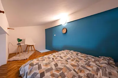 a bedroom with a blue wall and a bed at Podgorica City Center in Podgorica