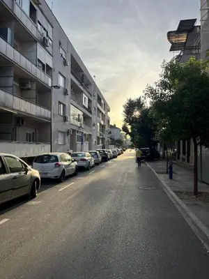 a street with cars parked on the side of a building at Podgorica City Center in Podgorica
