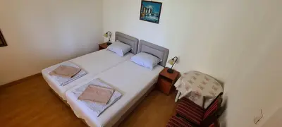 a small bedroom with a bed and a chair at Guest House Andrea in Budva