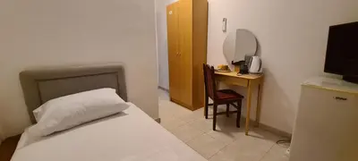 a bedroom with a bed and a desk with a mirror at Guest House Andrea in Budva