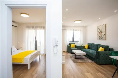 a bedroom and a living room with a bed and a couch at Apartments NIKOS FAMILY in Ulcinj